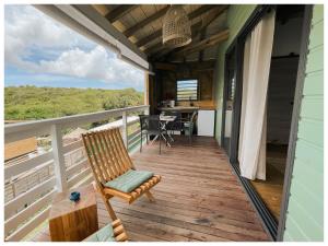 a wooden deck with a chair and a table at Les pilotis in Courcelles Sucrerie