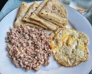 a plate of food with eggs and bread on it at Hudhuveli Residence in Muli