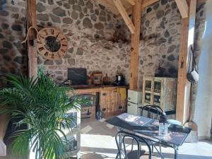 a kitchen with a table and a clock on the wall at L'envol des papillons in Lafarre