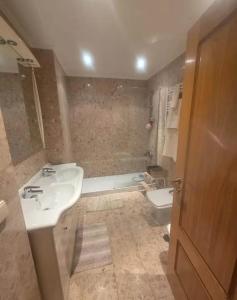 Un baño con lavabo, inodoro y bañera. en Casa Jones, en Lagos