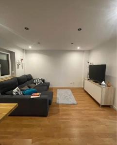 Una sala de estar con un sofá y un televisor de pantalla plana. en Casa Jones, en Lagos