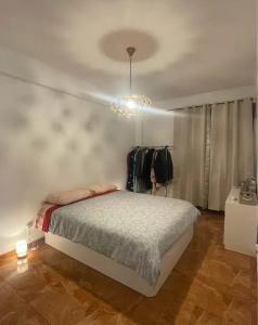 Un dormitorio con una cama y una lámpara de araña. en Casa Jones, en Lagos