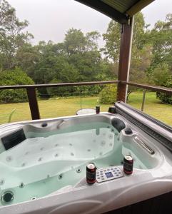 a jacuzzi tub on a porch with a view at The Hinterland Spa & Moon Retreat in Boyland