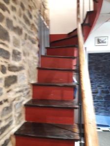 een trap in een huis met een stenen muur bij TINCHEBRAY Centre ville in Tinchebray