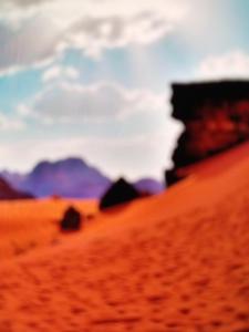 ワディ・ラムにあるRum Adventures Hostelの山を背景にした砂漠のぼやけた写真