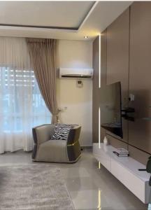a living room with a chair and a television at The Manor in Ikoyi