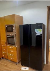 a black refrigerator next to a stove and a microwave at The Manor in Ikoyi