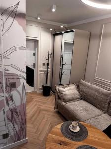 Una sala de estar con un sofá y una mesa de café. en Apartament Piastowska 2, en Polanica-Zdrój