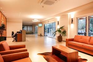 a lobby with couches and a table in a building at Studio 211 Conforto e Charme in Canela