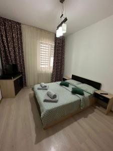 Un dormitorio con una cama con toallas. en Studio Central Ro1, en Râmnicu Vâlcea