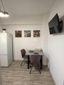 a dining room with a table and a refrigerator at Quantum Apartament 22 in Craiova