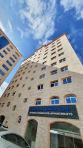 a tall building with a sign in front of it at البرق للشقق المفروشة in Salalah