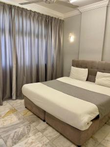 a bedroom with a large bed in front of a window at البرق للشقق المفروشة in Salalah