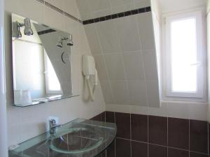 a bathroom with a sink and a mirror at Hôtel du Square d'Anvers in Paris