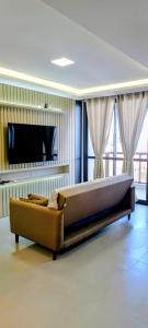a large couch in a living room with a television at Apartamento Novinho na Praia de Palmas em Gov Celso Ramos in Governador Celso Ramos