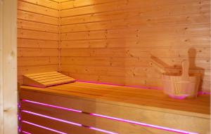 a wooden sauna with a bench and a bucket at Awesome Home In Jamnica Pisarovinska With Sauna in Jamnica Pisarovinska