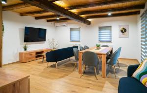 a dining room with a table and chairs and a television at Awesome Home In Jamnica Pisarovinska With Sauna in Jamnica Pisarovinska