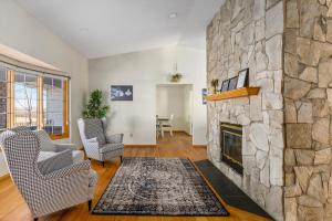 a living room with a stone fireplace at Acreage, 3 King Beds and Ensuites, Dance Floor, Fireplace, AC in Calgary