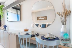 Refúgio Verão - Flat de alto padrão na praia do Cupe - Porto de Galinhas في بورتو دي غالينهاس: مطبخ به مرآة دائرية وكراسي زرقاء +49 صورة