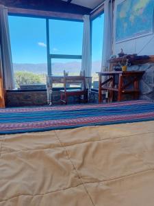 ein Wohnzimmer mit großem Fenster und Tisch in der Unterkunft Cabaña La Ermita, Complejo El Taller in Ciudad Lujan de Cuyo