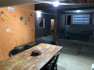 a room with a wooden table and chairs and a pool at Pousada Valley House in Piranhas