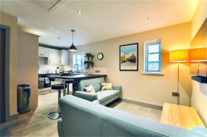 a living room with a couch and a kitchen at Luxury Two Bed Suite - Walk To Trentham Gardens! in Stoke on Trent