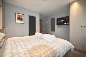 a bedroom with a bed with a tv on the wall at Luxury Two Bed Suite - Walk To Trentham Gardens! in Stoke on Trent