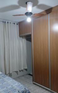 Un dormitorio con ventilador de techo y un armario. en Casa com área lazer, en Ribeirão Preto