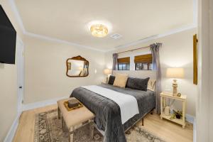 a bedroom with a bed and a chair and a mirror at The Brass Tulip in Tulsa