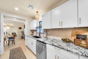 a kitchen with white cabinets and a counter top at The Brass Tulip in Tulsa