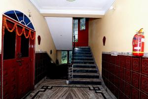 un escalier avec des portes rouges et une rampe d'escalier rouge dans l'établissement Hotel O Sonora Hotel, à Dhanbād