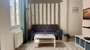 a living room with a couch and a table at Le Coignebert in Rouen