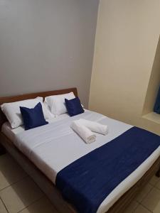 a bed with blue and white pillows on it at Tulia homes in Kanga