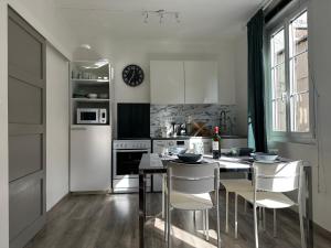 a kitchen with white appliances and a table and chairs at Le Coignebert in Rouen