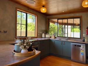 a kitchen with a sink and a dishwasher at Stillwater Residence - Lakeview Serenity Retreat in Ngongotaha