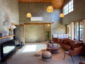 a living room with a couch and a fireplace at Stillwater Residence - Lakeview Serenity Retreat in Ngongotaha