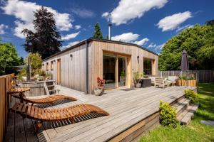 una terraza de madera con bancos y una casa en Chata Modřínka, en Seč