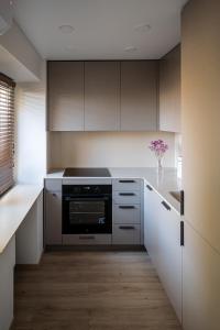 a kitchen with white cabinets and a black oven at Vytauto 12 in Marijampolė