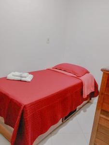 a bed with a red blanket on top of it at Casa Ampla com Garagem Ar-condicionado no Centro in Ananindeua +10 photos
