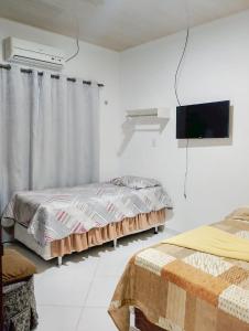 アナニンデウアにあるCasa Ampla com Garagem Ar-condicionado no Centroのベッド2台と薄型テレビ付きのベッドルーム