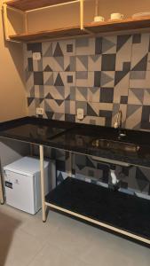 a kitchen counter with a sink and a tile wall at Pousada Green House Paraty in Paraty