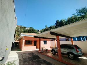 a car parked in a garage next to a house at Refúgio Estação in Guararema