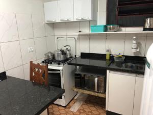 una cucina con mobili bianchi e un forno a piano cottura di Casa para Estadia a Foz do Iguaçu