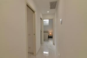 a hallway with white walls and a room with a bed at Central Apartment in Matera