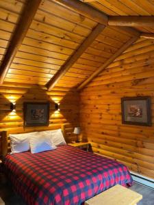 a bedroom with a bed in a wooden cabin at Auberge MicKy Inc in Edmundston