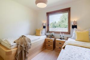 twee bedden in een kamer met een raam bij Chata Modřínka apartmány in Seč