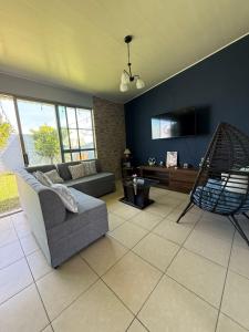 a living room with a couch and a chair at Casa en residencial Metrópoli San Gabriel, Nejapa San Salvador in Nejapa