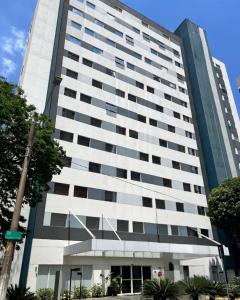 Un edificio alto y blanco con árboles delante. en Transamerica Wise Indaiatuba, en Indaiatuba
