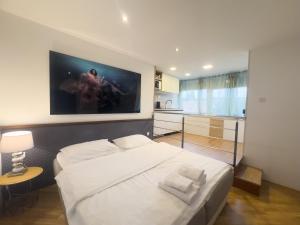 ein Schlafzimmer mit einem großen weißen Bett und einer Küche in der Unterkunft Dreams Apartment Bacvice in Split