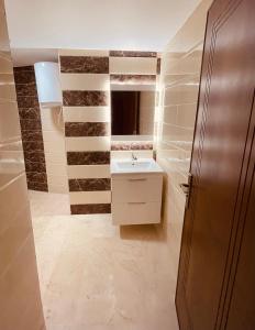 une salle de bain avec un lavabo et un miroir dans l'établissement 1CH & Salon,climatiseur-fibre optique-gare TGV 2min de la corniche malabata, à Tanger